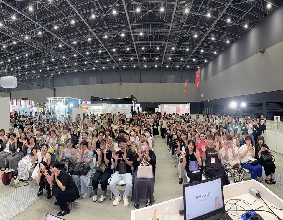 展示会場で開いたセミナーに集まり、笑顔で手を振る受講者たち