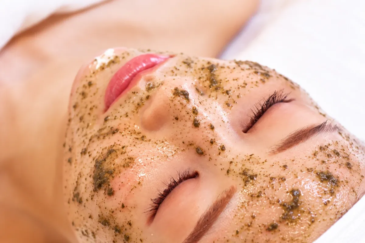 ハーブを使ったピーリングの施術を受ける女性